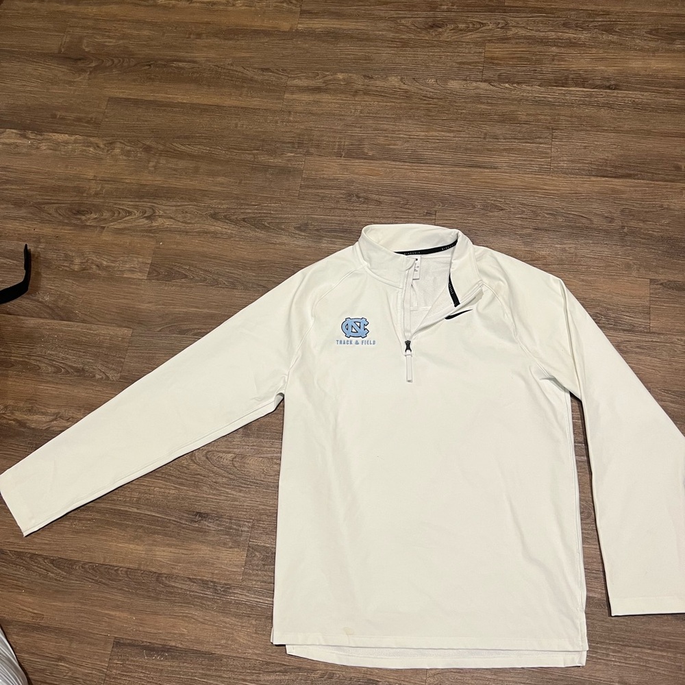 Clean white Nike UNC Golf pullover with track and field branding